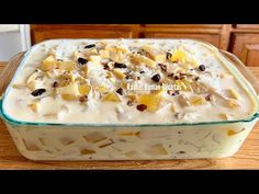 a casserole dish filled with fruit and nuts on top of a wooden table