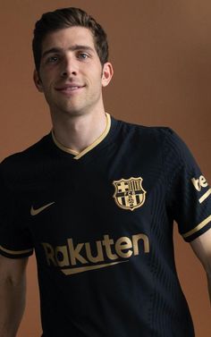 a young man in a black and gold soccer uniform posing for a photo with his hands on his hips