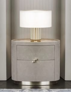 a white lamp sitting on top of a table next to a dresser with drawers underneath it