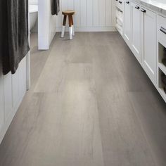 a kitchen with white cabinets and wood flooring on the walls is shown in this image