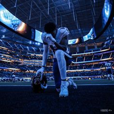 a football player kneels in the middle of an empty stadium