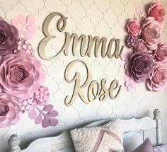 there is a bed with pink flowers on it and the name emna rose written in cursive writing