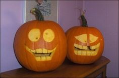 two pumpkins with faces carved into them sitting on a table in front of a purple wall