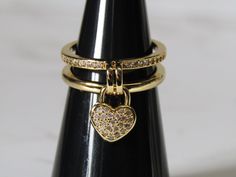 Hello and welcome to  TigerjewellerycoGB  Here we have a gorgeous Real 18k Gold Plated Cubic Zirconia Love Heart Dangle Charm Ring with an open Double band one band is plain and the other has small clear cubic zirconia stone's along the band   The details are striking with beautiful sparkling Clear micro pave cubic zirconia Heart dangle charm this ring would make a great addition to your jewellery collection.  This is an open ring.  One size fits most.  Gently bend open to required size.  Your s Ring Double Band, Double Band Ring, Double Band Rings, Charm Ring, 18k Gold Ring, Pave Ring, Cubic Zirconia Rings, Charm Rings, Dangle Charms