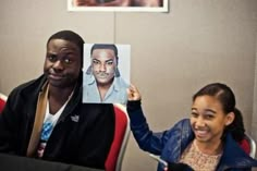 a man holding up a photo of himself and a woman