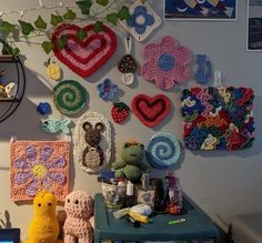 there are many crocheted hearts and teddy bears on the wall next to each other