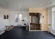 an indoor sauna room with black floors and white walls