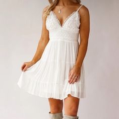 Charm every heart with the Joliet Tiered Mini Sundress. A delicate ivory white embroidered country boho day dress. It features adjustable straps, tie back detail, tiered ruffle skirt and a peekaboo back.  the perfect come and go dress for brunch dates,  warm days at the vineyard and farmer's market, country music concerts and romantic dates.  -Rayon/Polyester. -Elastic Waist.  -Dry Clean. -Fits True to Size -V-Neck -Sleeveless  -Adjustable Straps - unlined, semi sheer -Crochet Top -Self Tie At B Country White Dress, Sundress With Boots, Cowgirl Crochet, Engagement Photoshoot Outfit, White Lace Sundress, Country Dress, Lace Sundress, Clean Fits, Country Bride