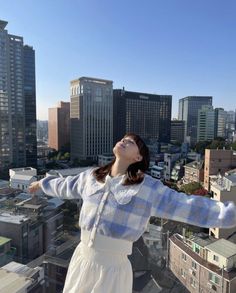 a woman standing on top of a tall building