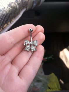 a person holding a silver flower shaped nose ring