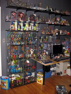 a room filled with lots of toys and shelves full of action figures on top of them