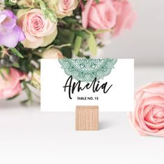 a table name card with pink roses in the background