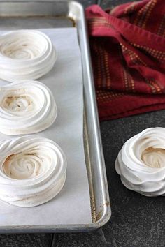 four cupcakes on a baking sheet with white icing in the middle, ready to go into the oven