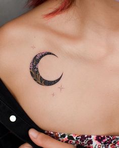 a woman's shoulder with a crescent tattoo on the left side of her chest