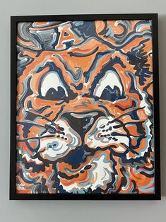 an orange and blue tiger painting hanging on the wall