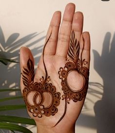 a person holding their hand up to show the hendi design on her face and hands