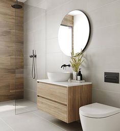 a bathroom with a toilet, sink and mirror in it's center piece is shown