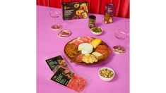 a pink table topped with lots of different types of food