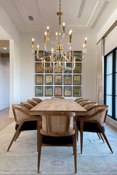 a dining room table with chairs and a chandelier hanging from the ceiling above it