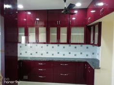 an empty kitchen with red cabinets and white tile backsplashes on the walls