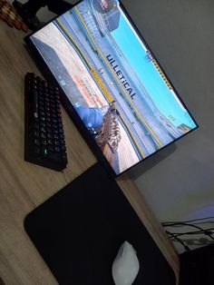 a computer monitor sitting on top of a wooden desk next to a keyboard and mouse