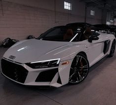 a white car parked in a garage next to other cars