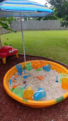 an inflatable sand and water play set with umbrella on the ground next to it