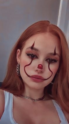 a woman with red hair and makeup is wearing a clown nose ring around her neck