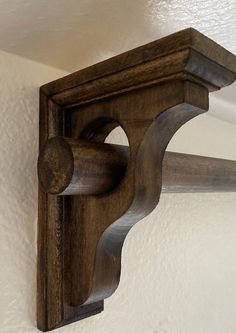 a wooden shelf mounted to the side of a wall with a sign that says diy curtain rod