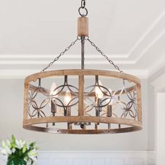 a wooden chandelier hanging from the ceiling in a room with white walls and flooring