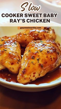 some chicken is sitting on a plate with sauce in the middle and text overlay reads slow cooker sweet baby ray's chicken