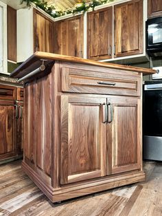 a kitchen with wooden cabinets and stainless steel stove top ovens in the center, surrounded by wood flooring