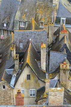 an aerial view of rooftops and chimneys in a city with old buildings, including one building that has been gutted