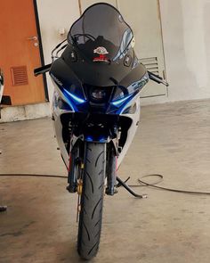 a motorcycle parked in a garage with its lights on and it's front wheel still attached to the bike