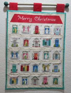 a quilted christmas calendar hanging on a wall with the words merry christmas written across it