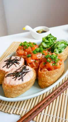 some food on a plate with chopsticks next to it