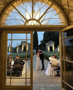 a bride and groom standing in front of an open door at their wedding reception outside