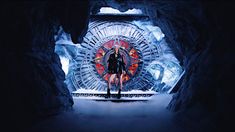 a man standing in front of a giant clock with red lights on it's face