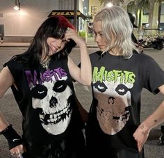 two women standing next to each other with their hands on their head and wearing matching t - shirts