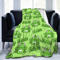 a green frog blanket sitting on top of a couch