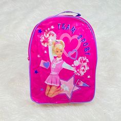 a pink backpack with a barbie doll on the front and stars in the back that says, tasty day