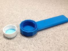 a blue object sitting on top of a counter next to a white bowl and spoon