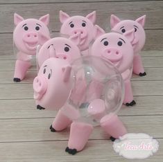 five pink pig figurines are shown on a wooden floor with a clear bubble