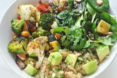 a white bowl filled with different types of vegetables and rice on top of a table