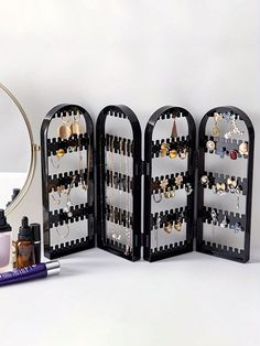 an assortment of jewelry is displayed in the shape of a rack with earring holders