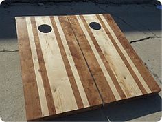 two pieces of wood with holes in them sitting on the ground next to each other