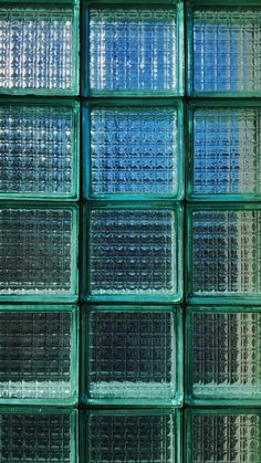 many glass blocks are stacked together in the same square pattern, with different colors and sizes