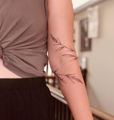 a close up of a person with a tattoo on their arm and the other arm behind her