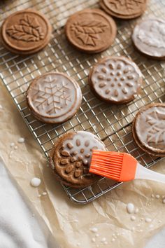 some cookies are cooling on a rack with a brush