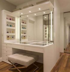 a dressing table with a stool in front of it and shelves on the wall behind it